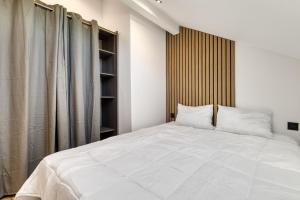 a bedroom with a large white bed with a wooden headboard at La Lunaria - chambre en colocation in Collonges-sous-Salève