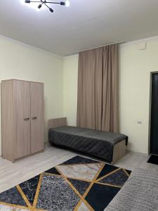 a bedroom with a bed and a cabinet in it at Koksay Hotel in Almaty