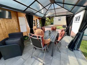 a screened in patio with a table and chairs at Casa Edelsita in Hoppegarten