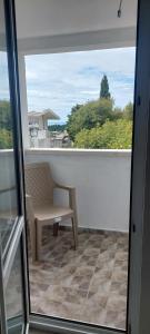 Un balcón con un banco y una ventana. en Apartmani.Sutomore, en Sutomore