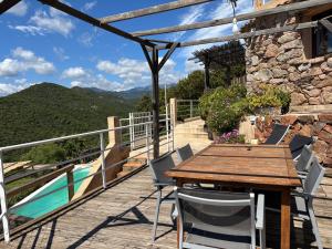 una mesa de madera y sillas en una terraza con vistas en CAROLE F3, en Sainte-Lucie de Porto-Vecchio