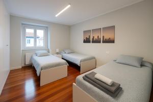 a bedroom with two beds and a window at Apartamento en el centro de 2 hab. y 2 baños. in Castro-Urdiales