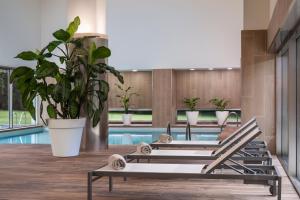 a row of lounging chairs next to a pool at NH Collection Santiago de Compostela in Santiago de Compostela