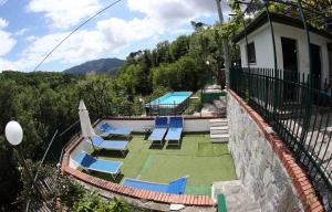 grupa leżaków i parasoli na balkonie w obiekcie Villa Maremonti - con 3 piscine w mieście Sestri Levante