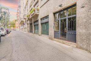 una strada vuota accanto a un edificio con macchine parcheggiate di Milan center JACUZZI DELUXE LOFT a Milano