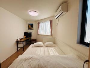 a bedroom with two beds and a window at 东京池袋城市住宿-Ikebukuro Urban Stay in Tokyo