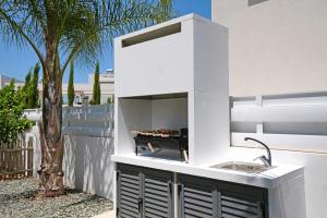 a kitchen with a sink and a palm tree at Villa Evergreen - 3bed Bungalow large pool in Protaras