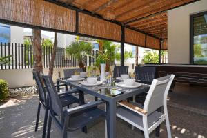a dining room table with chairs and a piano at Villa Evergreen - 3bed Bungalow large pool in Protaras