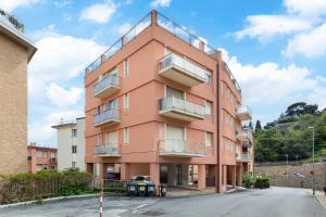 a pink building with balconies on a street at Hostdomus-Casa Marais in Finale Ligure