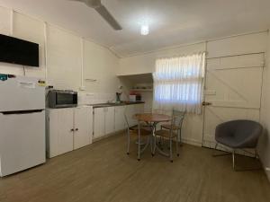 a kitchen with a table and chairs and a refrigerator at The Captains Manor On Cook 5 in Arcadia