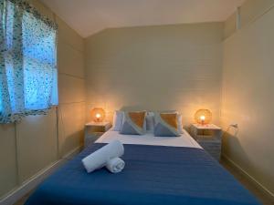 a bedroom with a blue bed with towels on it at The Captains Manor On Cook 5 in Arcadia