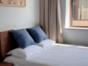 A bed or beds in a room at 蓬莱楠舍清和民宿 蓬莱阁海水浴场店