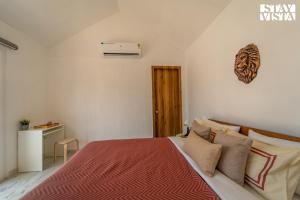a bedroom with a bed with a red blanket and pillows at StayVista at The Leo's Manor with Bonfire, Pool in Jaipur +27 photos