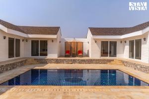 a home with a swimming pool and a house at StayVista at The Leo's Manor with Bonfire, Pool in Jaipur