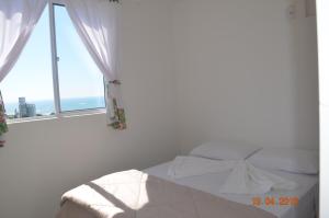 1 dormitorio con cama y ventana abierta en Residencial Lunata, en Penha