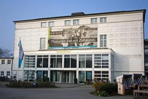 ein großes weißes Gebäude mit einem Schild darauf in der Unterkunft Badehaus Norderney in Norderney