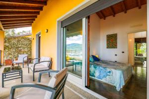 a room with a bed and a balcony with a view at Villa Mavica in  Monvalle 