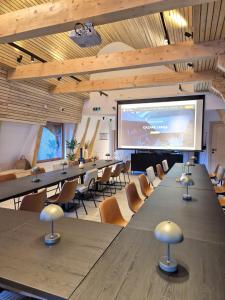 a conference room with tables and a projection screen at Casa Tisaru in Lepşa