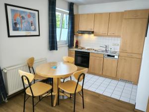 Una cocina con una mesa y sillas y un fregadero. en Südstrand 03, en Göhren