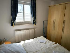 Un dormitorio pequeño con una cama y una ventana. en Südstrand 03, en Göhren