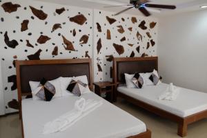 two beds in a room with a wall covered in footprints at Sundown Resort & Austrian Pension House in Boracay