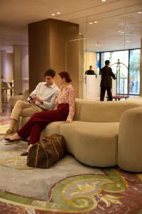 a man and a woman sitting on a couch at Astor Hotel Athens in Athens