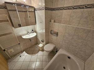 a bathroom with a sink and a toilet and a tub at Ostseekoje im Haus zwischen den Wassern in Behrensdorf +11 photos