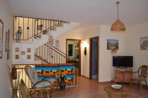 Una sala de estar con escalera y televisor. en Aspra Mare House, en Ficarazzi