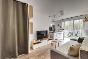 a living room with a couch and a television at Le Cosy De l'Ourcq T2 40m2 20 min de Paris in Villepinte
