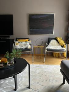 a living room with two chairs and a table at Leilighet Rjukan sentrum in Rjukan