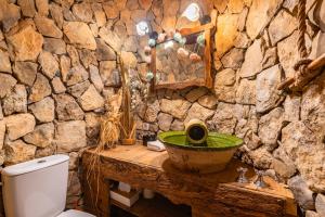 un bagno in pietra con lavandino e WC di La Casita De Las Estrellas ad Algimia de Almonacid Altre 29 foto