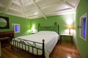 a bedroom with a large bed with green walls at Aretousa Studios & Apartments in Skopelos Town +52 photos