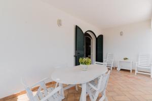 Un comedor blanco con una mesa y sillas blancas. en Casa della Musica - Salento Selection, en Torre Santa Sabina