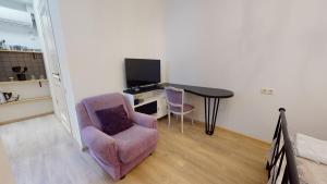a living room with a table and a chair and a desk at Cosy Apartment in the heart of old Tbilisi in Tbilisi City