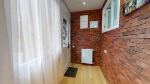 a hallway with a brick wall and a window at Cosy Apartment in the heart of old Tbilisi in Tbilisi City +2 photos