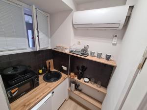 a small kitchen with a sink and a microwave at Cosy Apartment in the heart of old Tbilisi in Tbilisi City