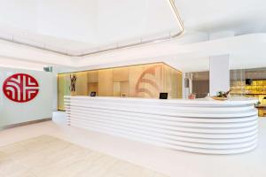 a lobby with a large white wall at NH Collection Köln Mediapark in Cologne