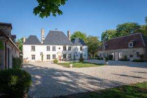 布尔日Le Château du Sollier - Charme calme et confort climatisation à 5mn du peage的一栋有宽阔车道的白色大房子