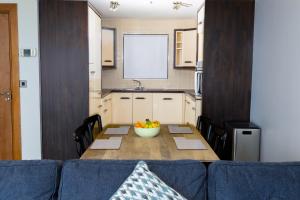 a kitchen with a table with a bowl of fruit on it at Tur an Tsaile - Galway Lakeside Apartments in Galway