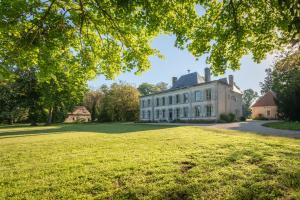 布尔日Le Château du Sollier - Charme calme et confort climatisation à 5mn du peage的一座大型白色房子,设有大片草地