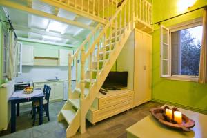 a kitchen with green walls and a staircase in a room at Aretousa Studios & Apartments in Skopelos Town