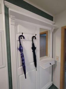 two umbrellas hanging on a door in a room at Rhein Ferienwohnung 3-Zimmer Garten Free Parking Netflix Premium Disney Premium in Koblenz