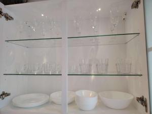 a glass shelf with bowls and glasses on it at Rhein Ferienwohnung 3-Zimmer Garten Free Parking Netflix Premium Disney Premium in Koblenz +48 photos