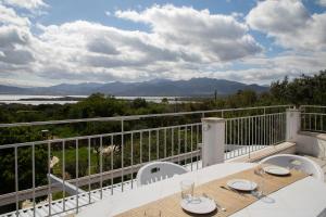 ein Balkon mit Tisch und Stühlen und Aussicht in der Unterkunft Villetta Otis by Wonderful Italy in San Teodoro