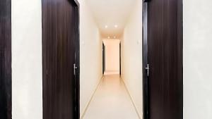 un pasillo con puertas negras y paredes blancas en Grand Darbar, en Bānda