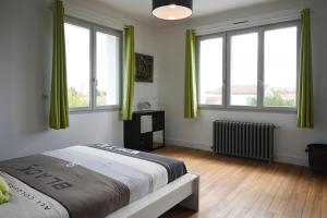 una camera da letto con tende verdi e un letto in esso di La Villa Palmier - Piscine avec Grand Jardin a Meschers-sur-Gironde Altre 18 foto