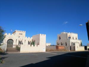 a large white building with a blue sky in the background at Casa Rural La Alcazaba in El Robledo