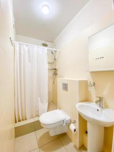 a white bathroom with a toilet and a sink at Shpinat in Odesa +29 photos