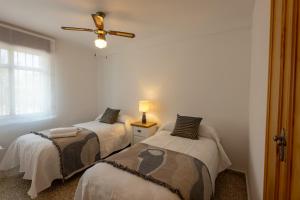 a bedroom with two beds and a ceiling fan at Comeback LOOKING FOR THE SUMMER in Motril