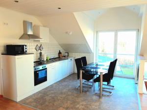 a kitchen with a table and chairs and a dining room at Seyfarthrooms - Großröhrsdorf 2 - zentrale Lage, stilvolle Einrichtung, Blick in den Garten in Großröhrsdorf
